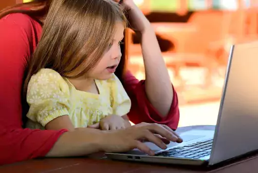 child at computer with parent