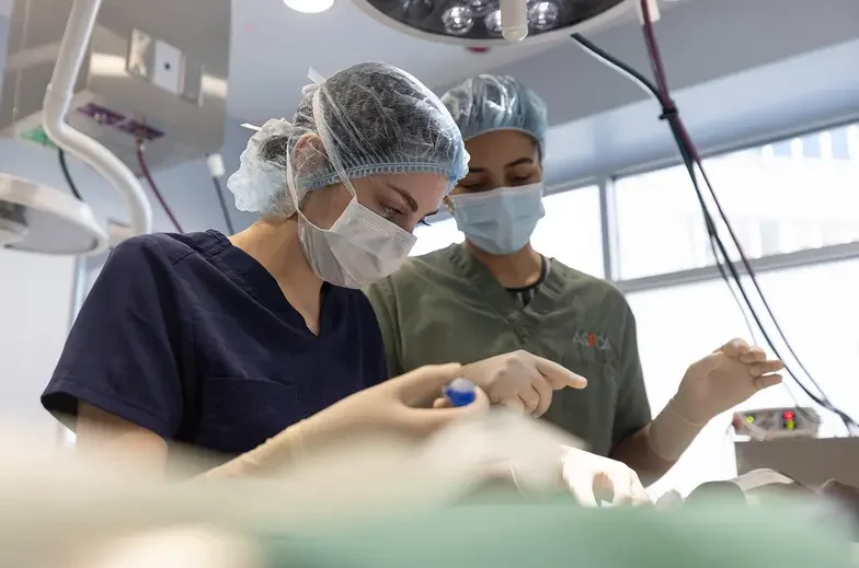 Two medical staff perform a procedure in the clinic