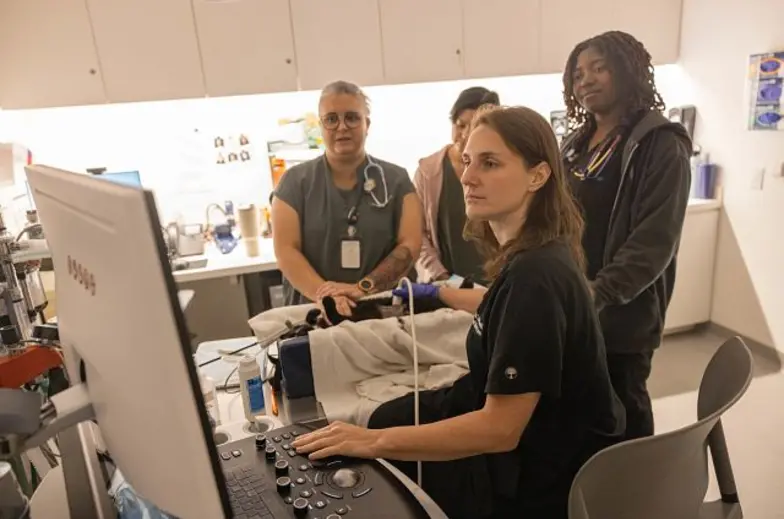 Three interns observing a doctor