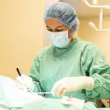 Person in scrubs performing surgery