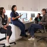 Four members of clinic staff hold a meeting in a room of the clinic