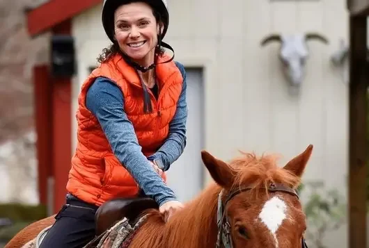 Melissa Thibault riding a brown and white horse