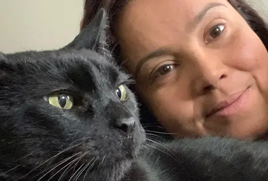 Photo of Nicole Dockrey next to black cat