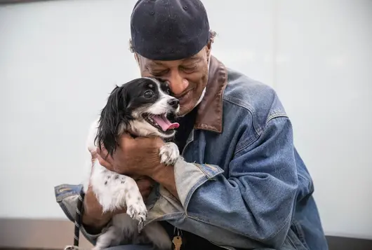 Man holding black and white dog