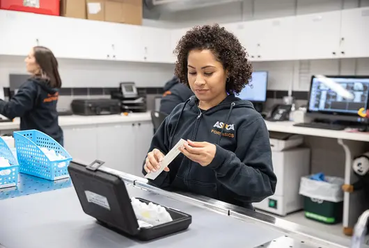 aspca forensics staff works in a lab with laptops and swabs during an investigative examination