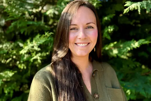 Headshot of Megan Dennis against trees
