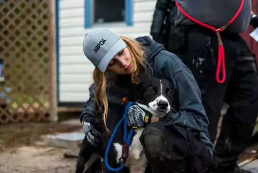 woman holds onto scared dog