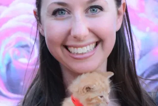 headshot of woman holding kitten