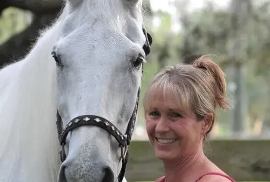 stacy pace smiling with white horse