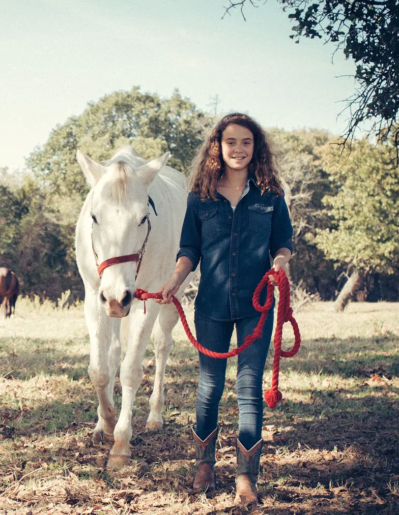 young girl with white horse on lead