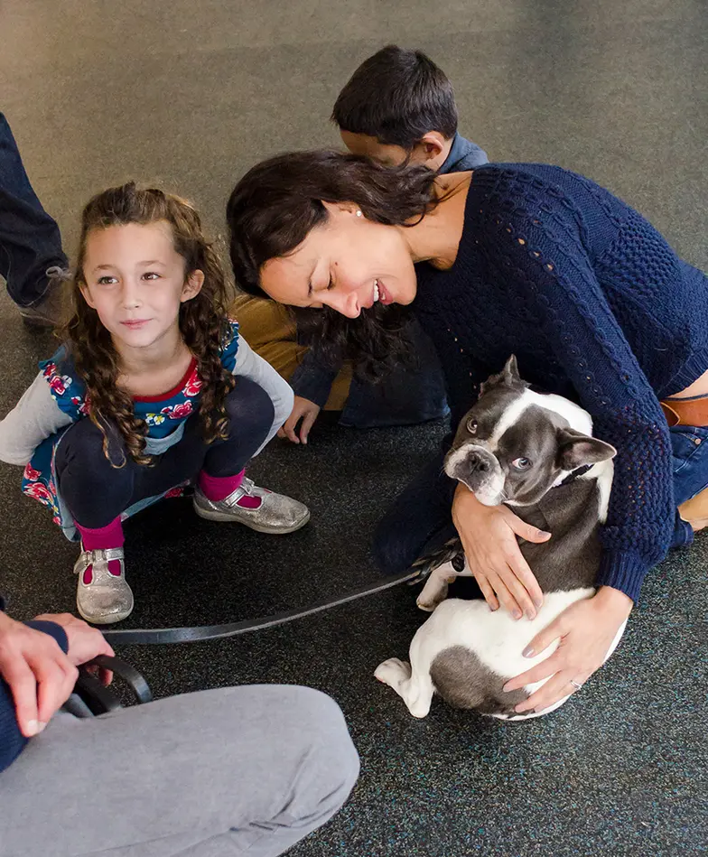 family holding dog on floor