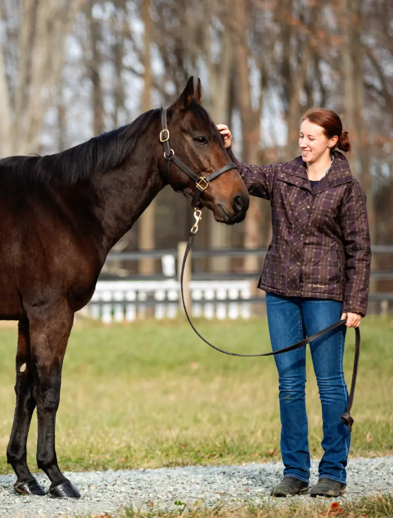 smiling woman with brown horse outdoors