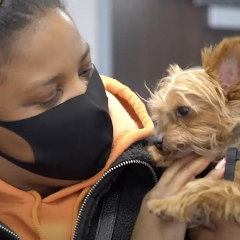 woman holds small dog after services at bronx cvc