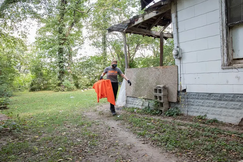 rescue staff carrying a covered crate from hoarding