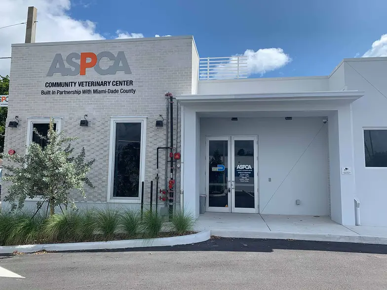 exterior of the white, single story ASPCA veterinary center in Miami blue skies