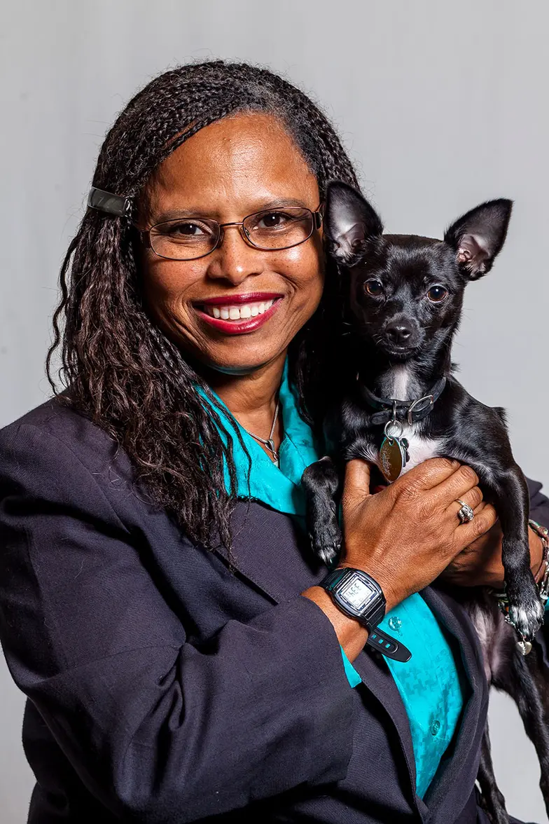 Dr. Lila Miller holding a small black and white dog
