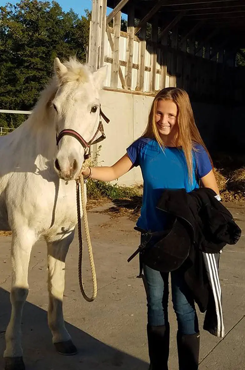 girl holding white horse
