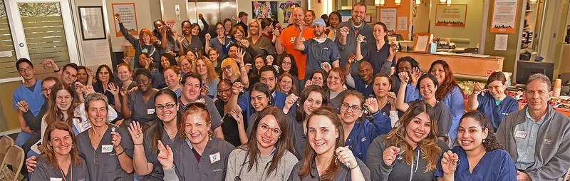 large group of veterinary staff wearing scrubs smiling